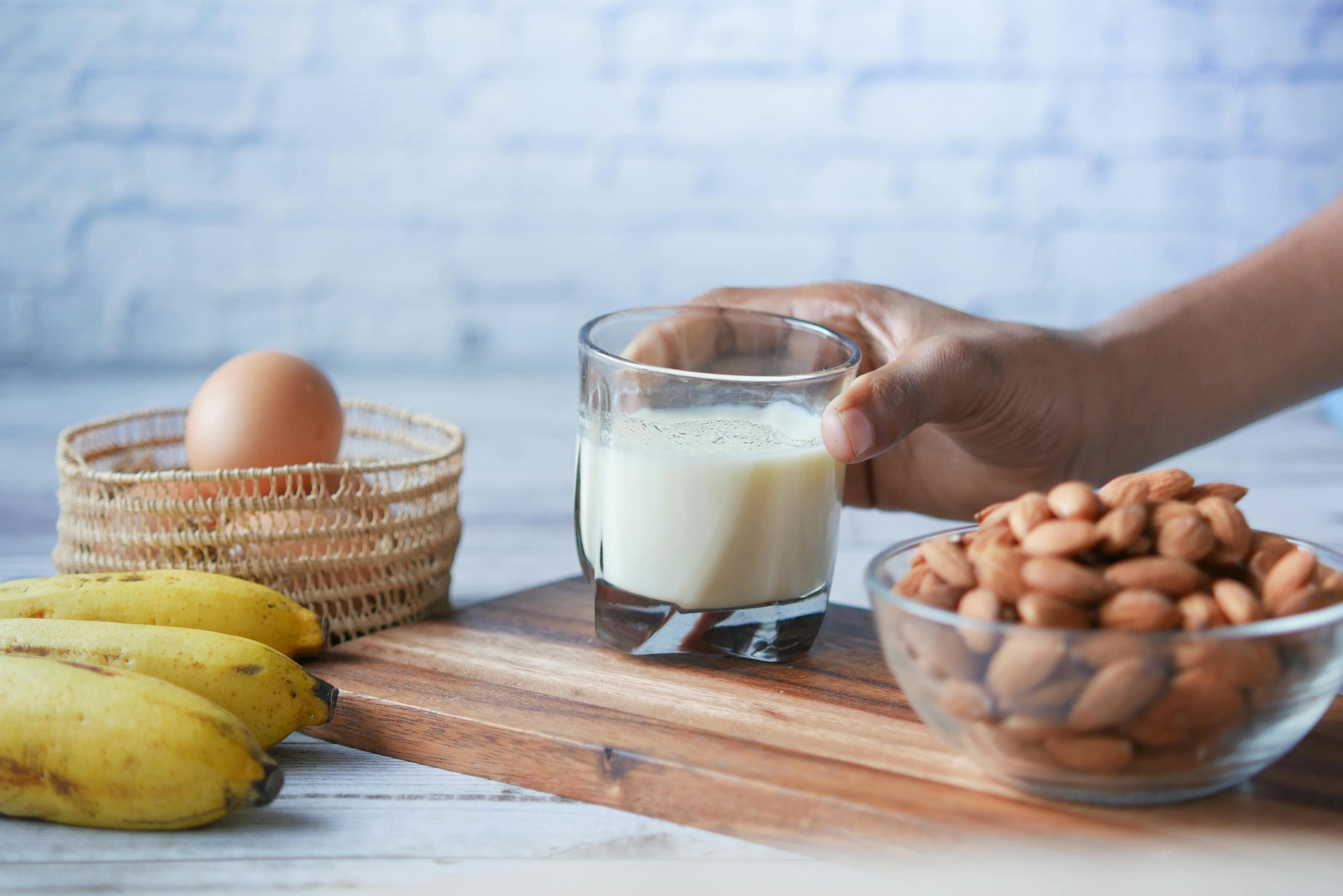 Glass of milk, nuts, eggs and bananas