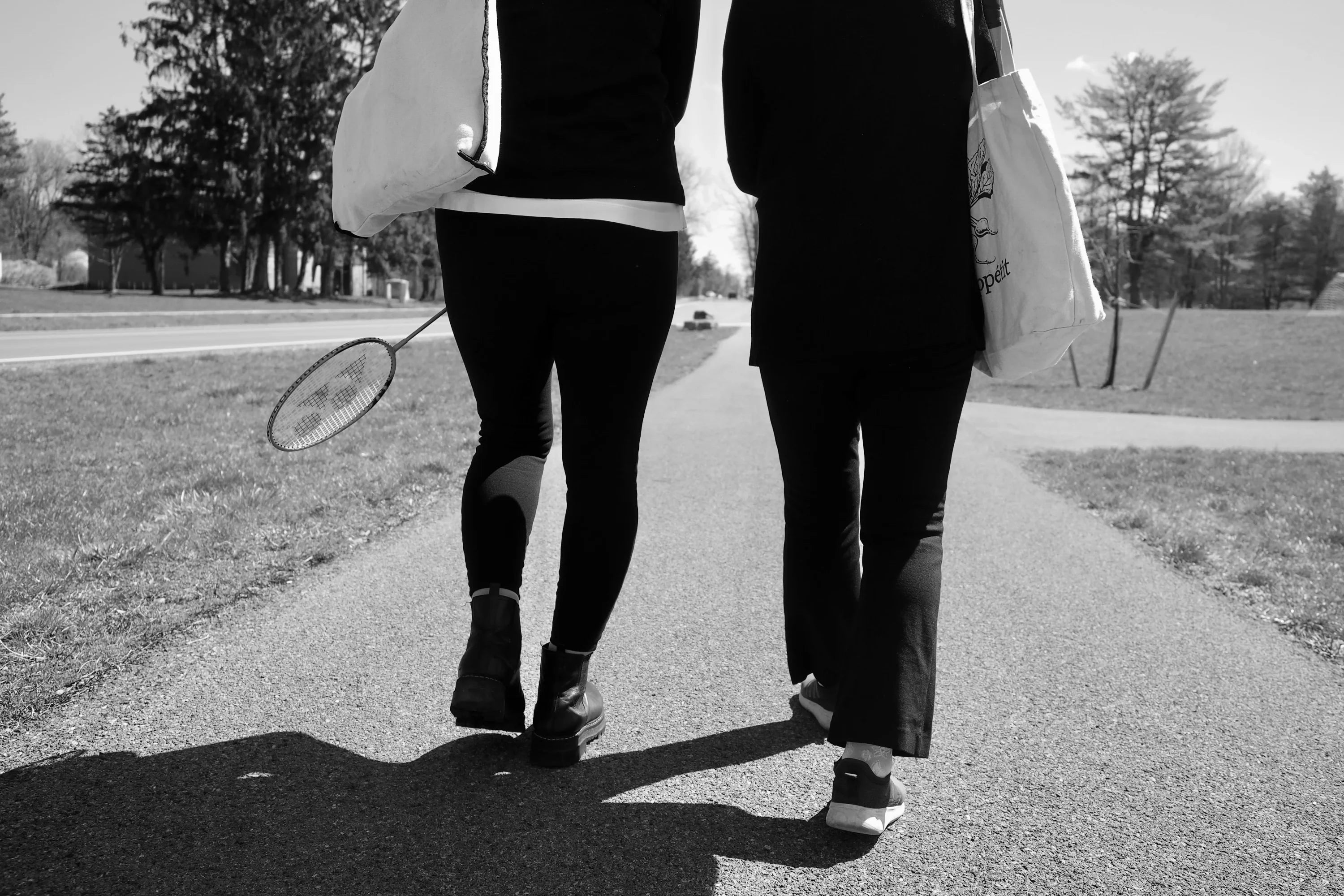 Women with rackets walking on path