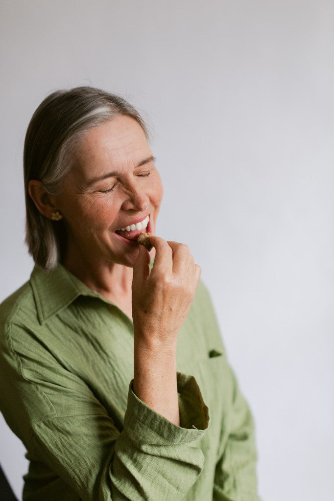 A customer smiling as she eats a Seen calcium chew